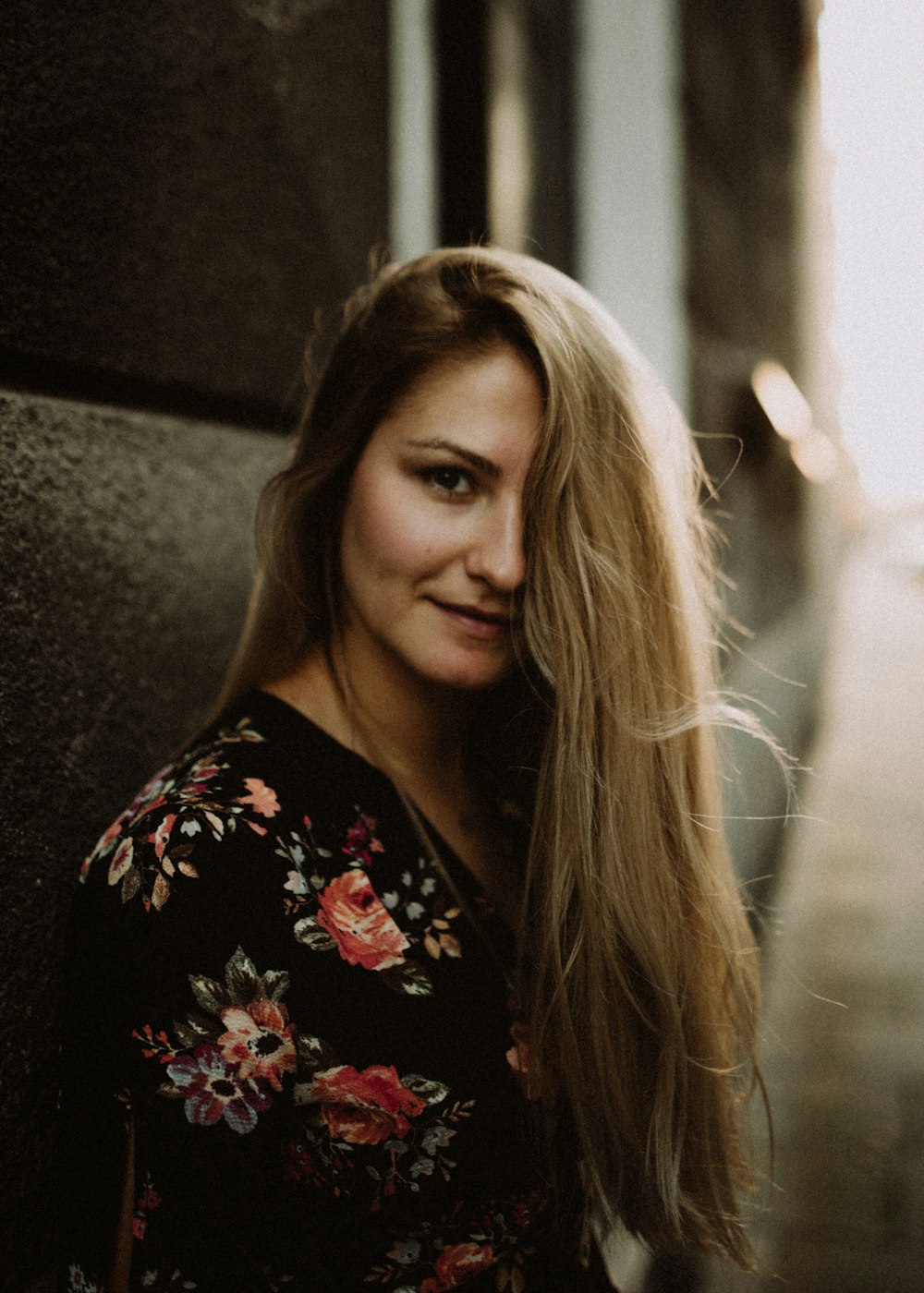 Femme appuyée sur un mur de béton gris