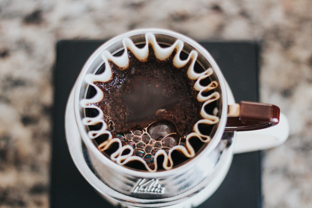 white and brown mug with coffee