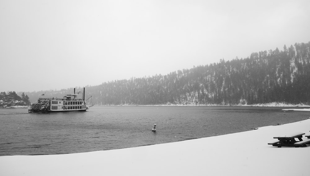 Foto en escala de grises de un barco en un cuerpo de agua