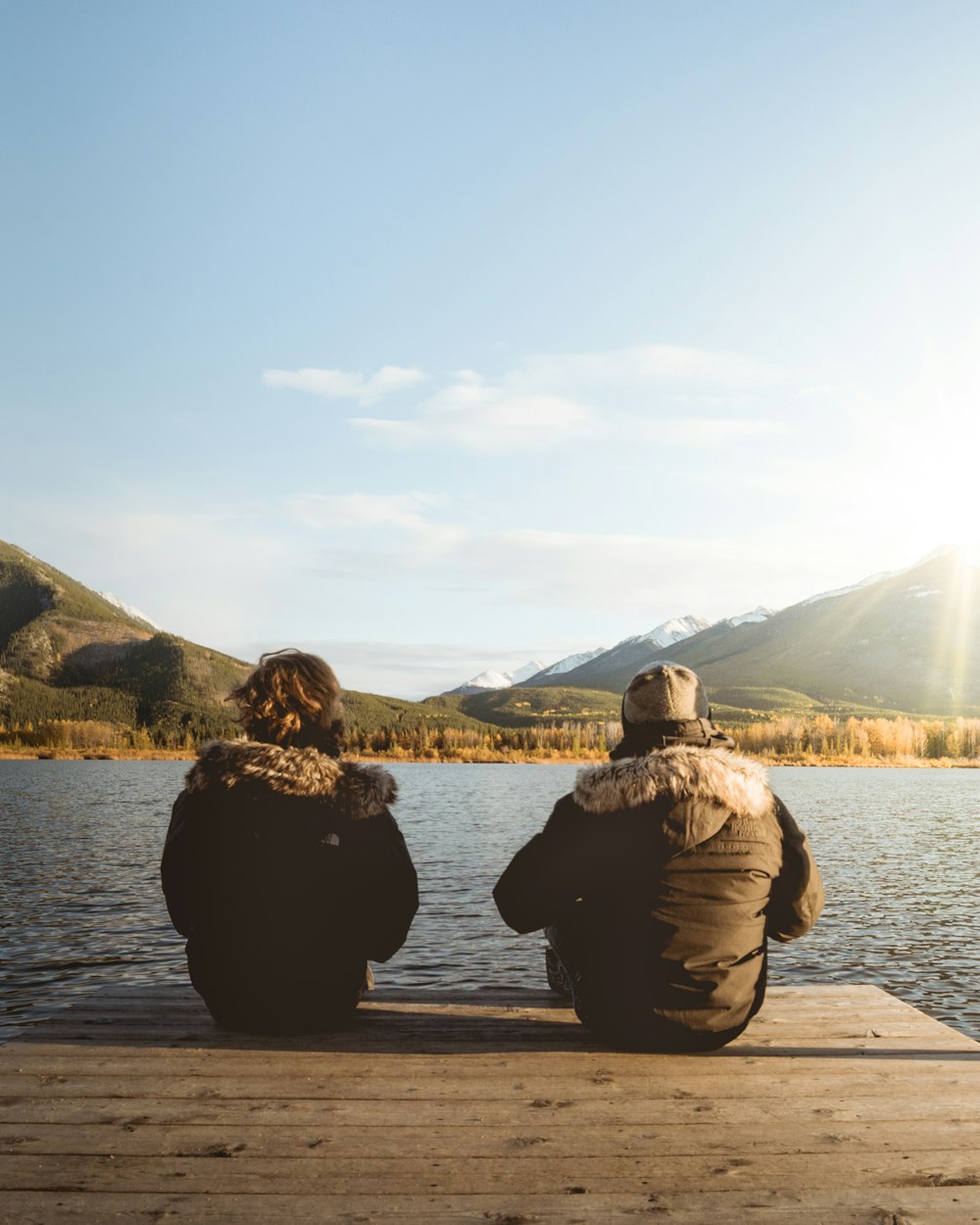 two women sitting on dock at daytime