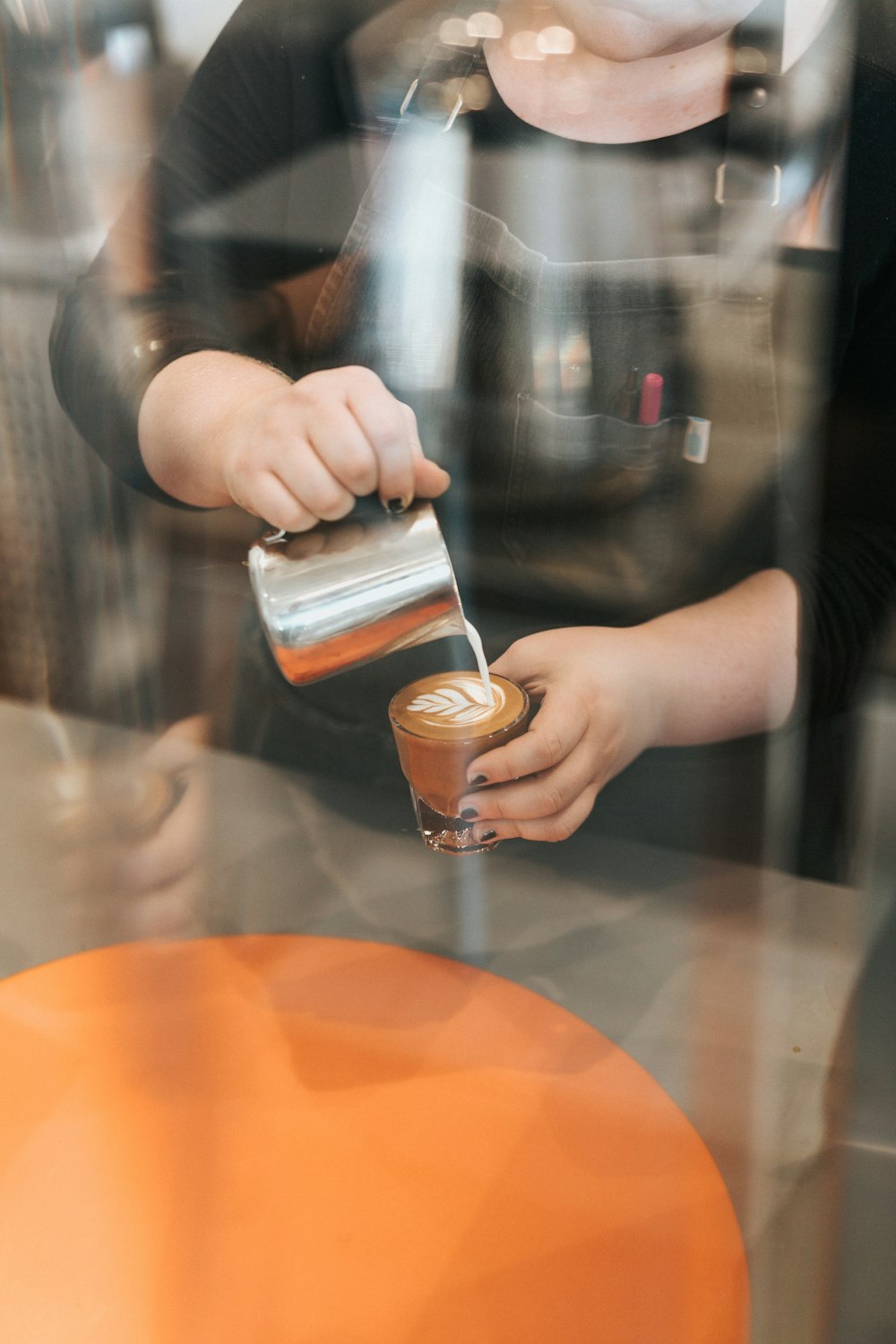 a woman pouring a cup of coffee on top of a table