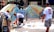 A group of diverse people creating art together in a vibrant, outdoor setting.