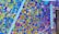 A vibrant mosaic artwork composed of multiple small, colorful tiles arranged in a dynamic, abstract pattern. The tiles vary in color and size, creating an intricate and lively visual effect.