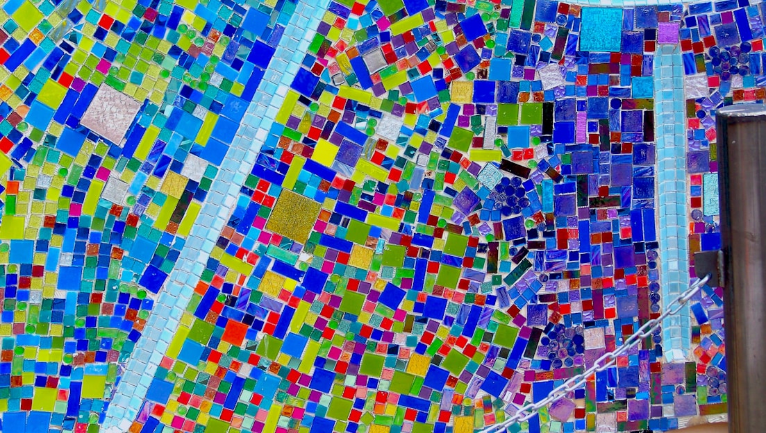A vibrant mosaic art piece displayed on a rustic wooden table.