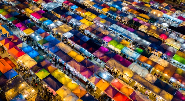 An aerial view of a bustling market filled with colorful goods.
