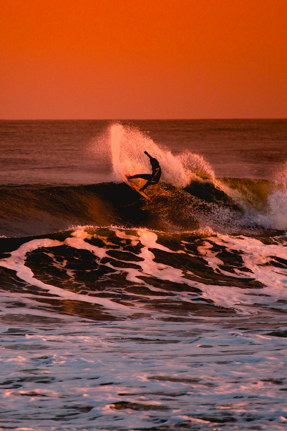 Persona che fa surf durante il tramonto