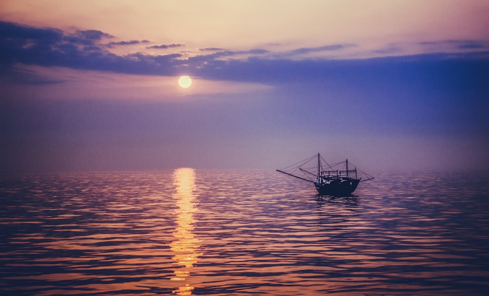 silhouette photo of sailing boat during golden hour