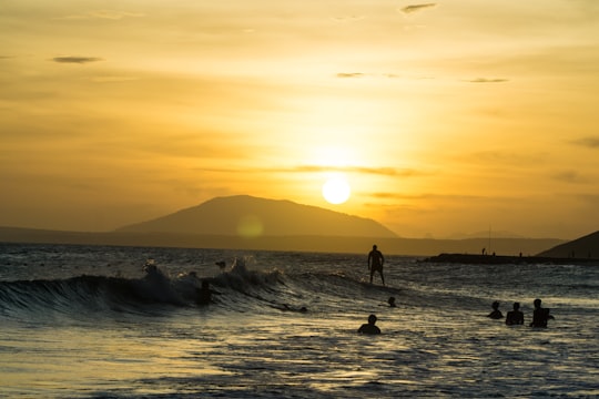 people swimming on body of water with distance to mountain in Mui Ne Vietnam