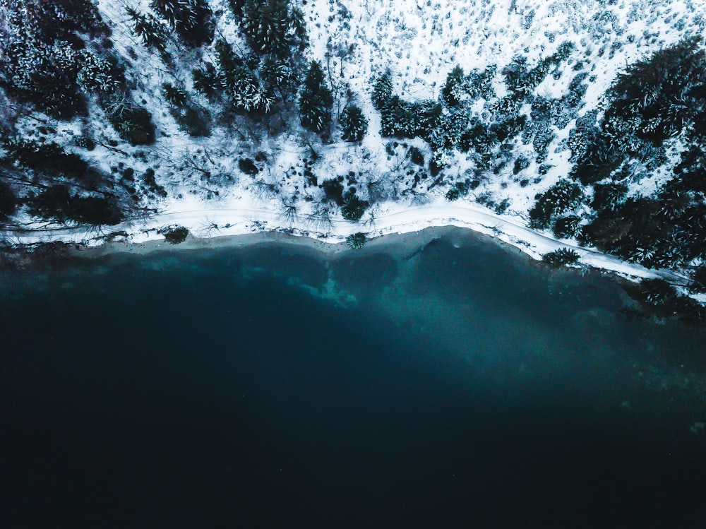 body of water near snowy mountain