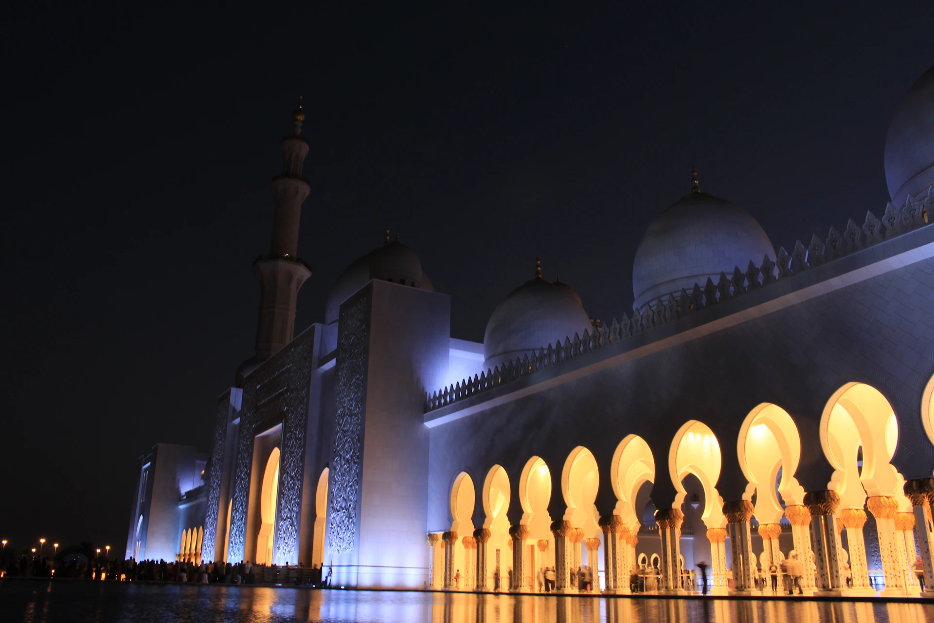The majestic Masjid Nabawi illuminated at night, highlighting its elegant navy and gold color accents.