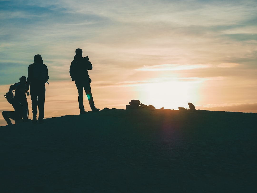 group of people standing atop of mountain