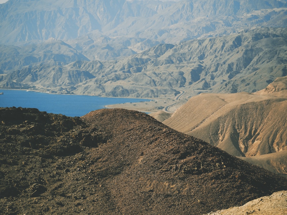 hill near body of water at daytime