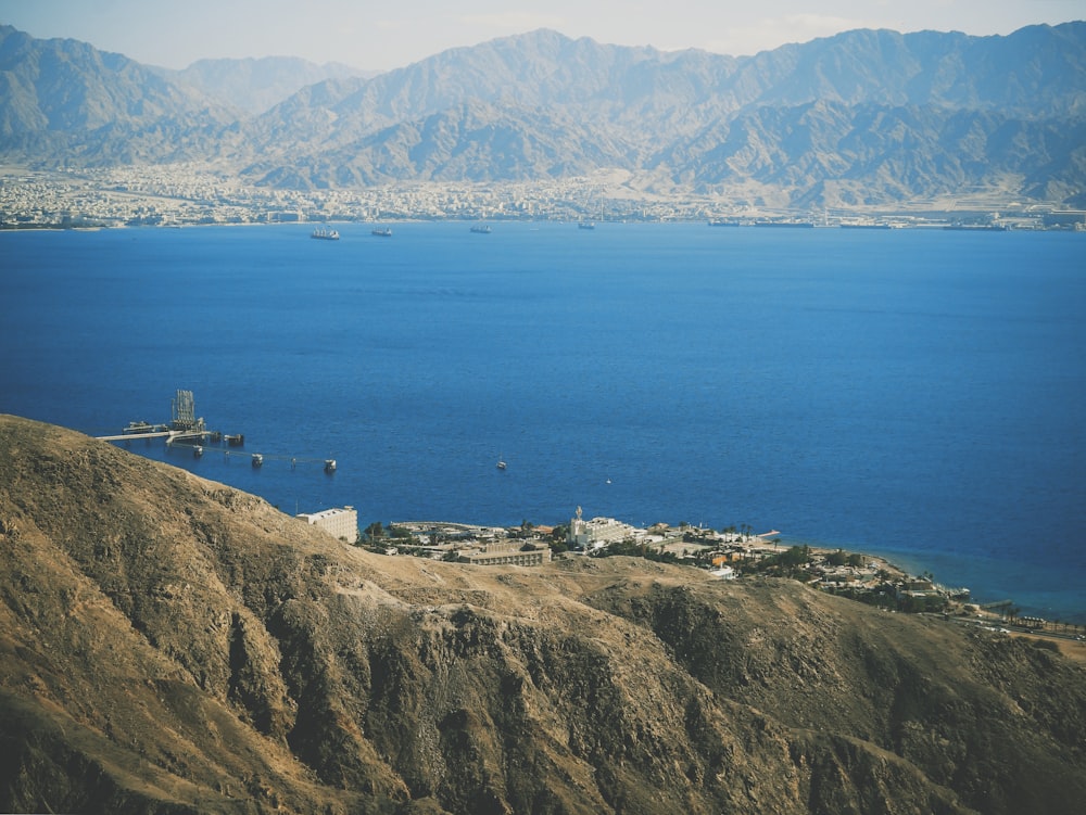 aerial photography of blue body of water near brown mountains