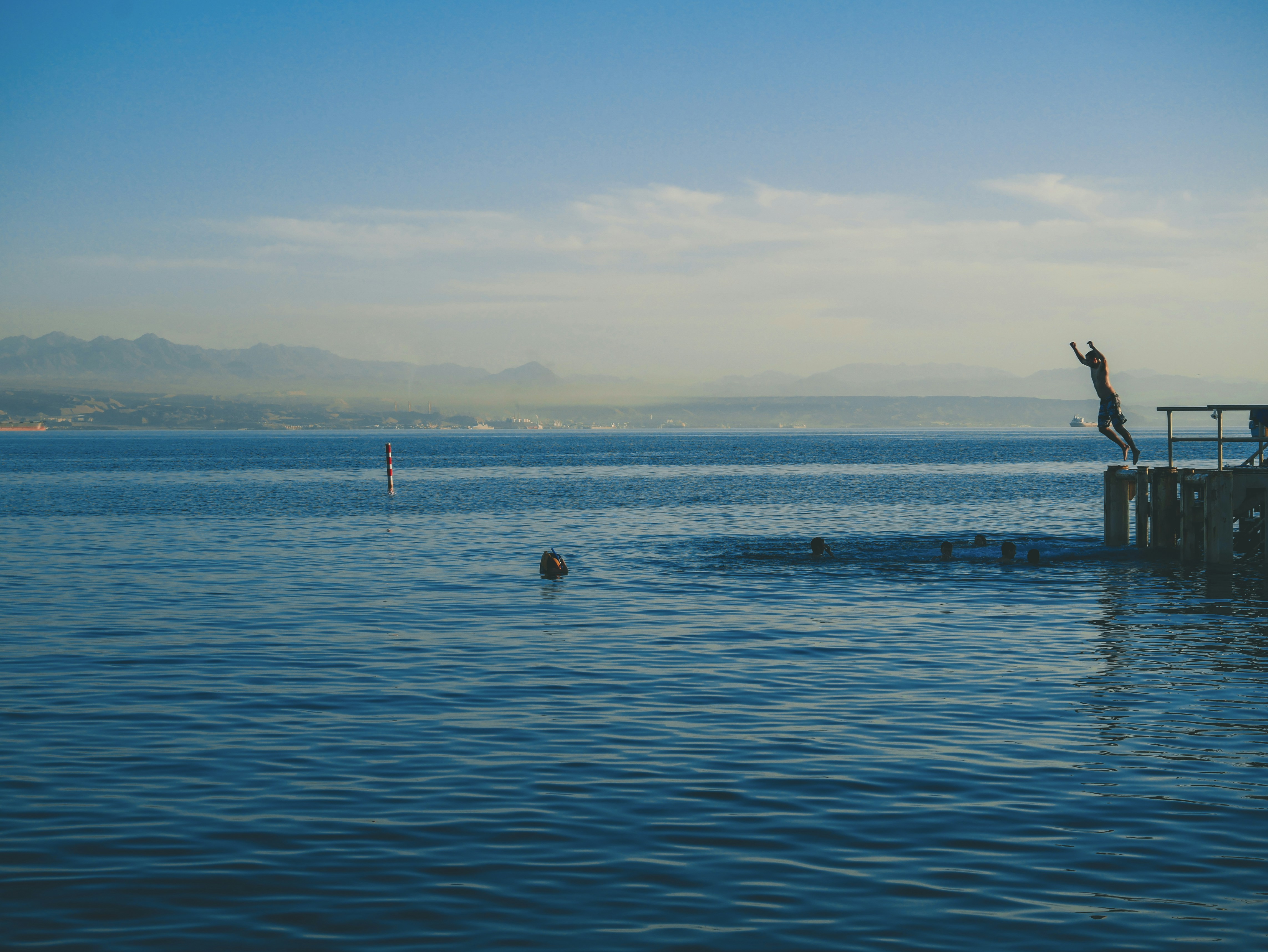man about to jump on ocean at daytime