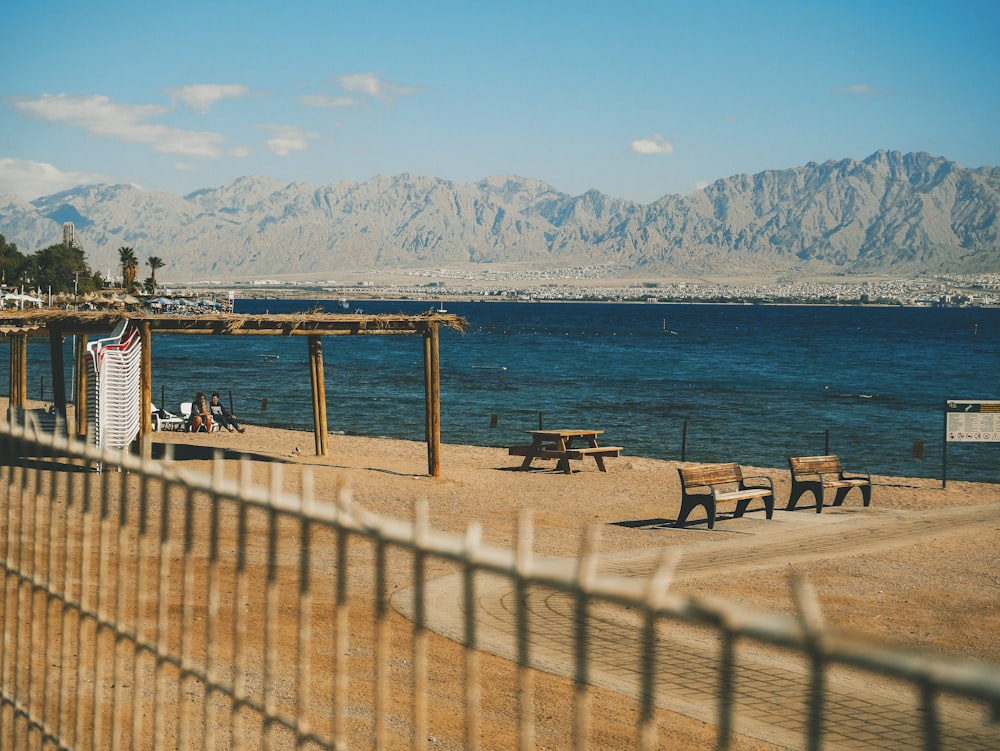 photography of picnic table beside body of water