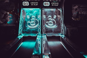 two black-and-blue lighted skeeball tables