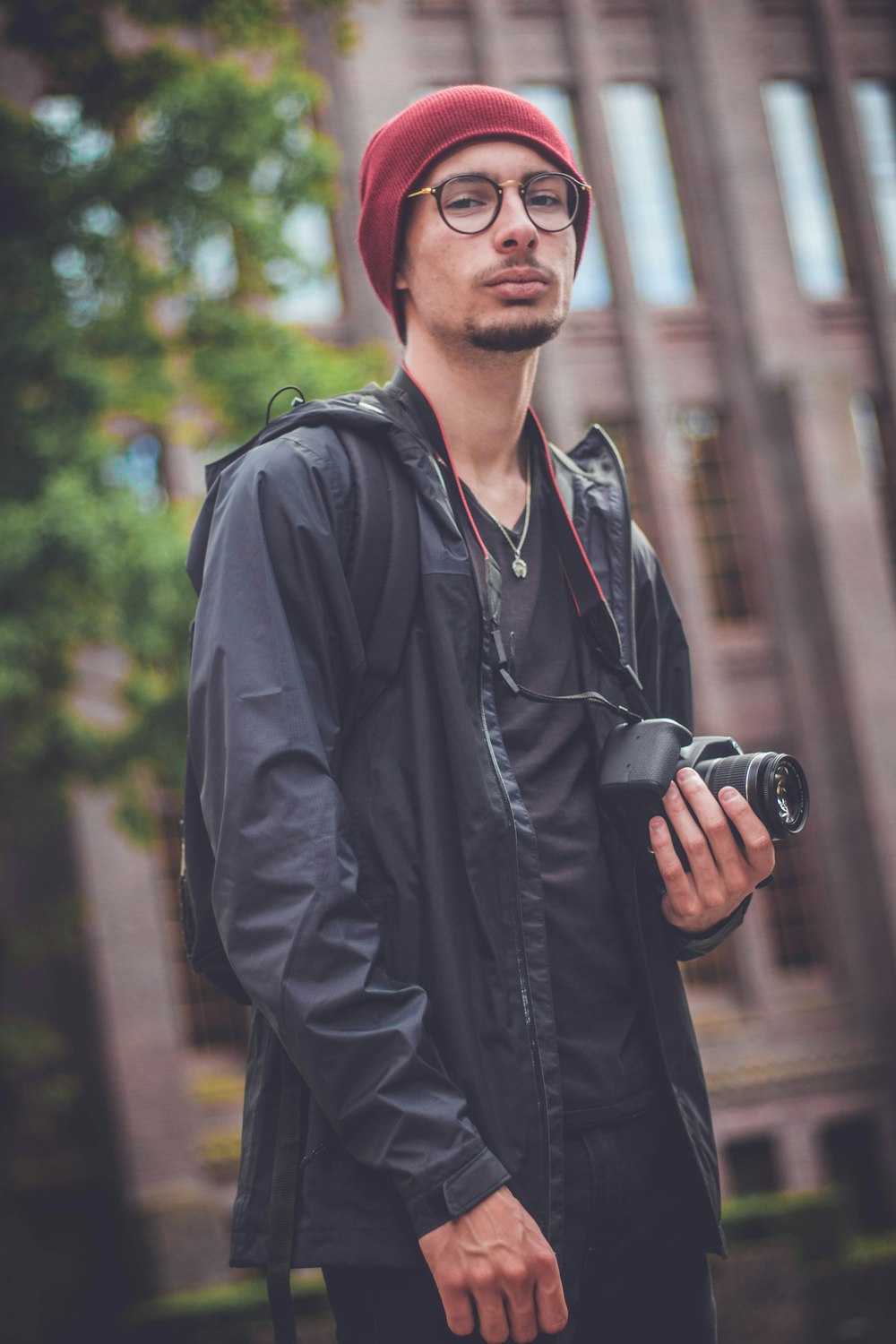 homem segurando câmera DSLR preta