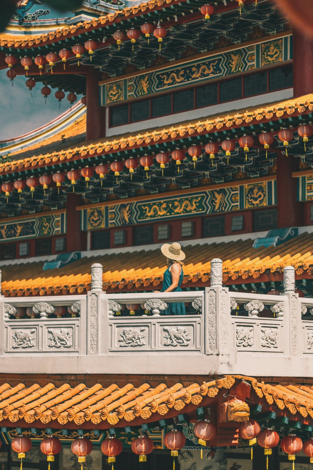 woman standing on gray patio of pagoda during daytime