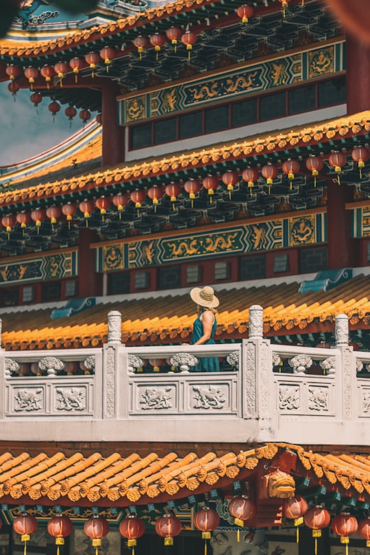 woman standing on gray patio of pagoda during daytime in Thean Hou Temple Malaysia