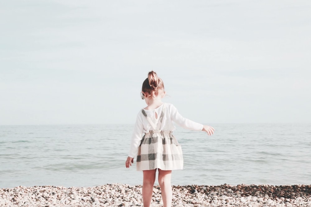 menina caminhando em direção ao mar