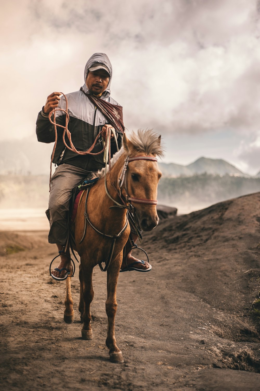 man riding horse under cloudy skies