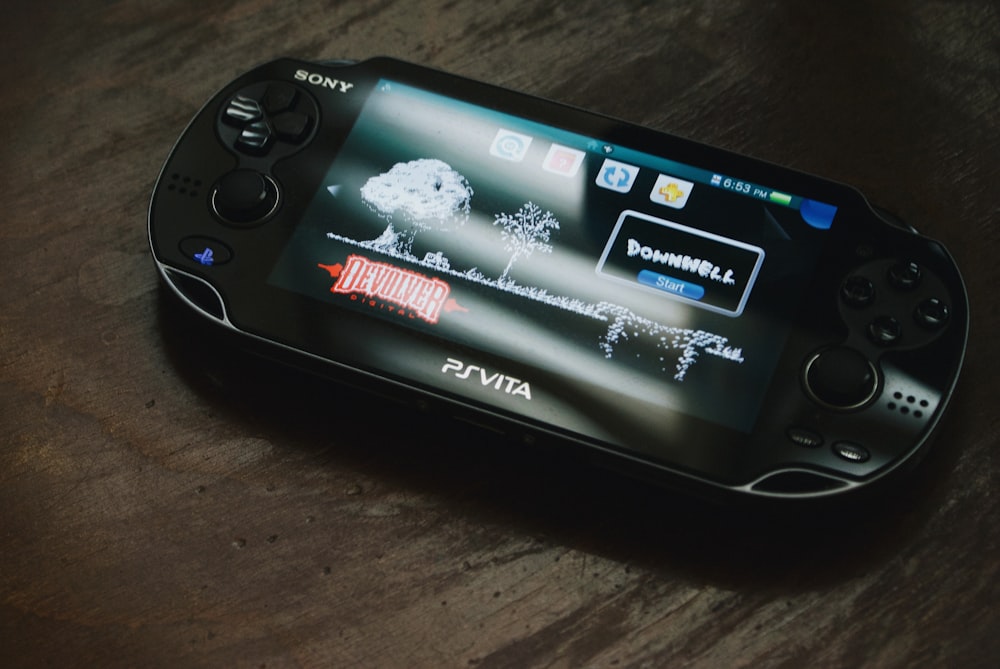 茶色の木製の表面に黒いソニーPS Vita