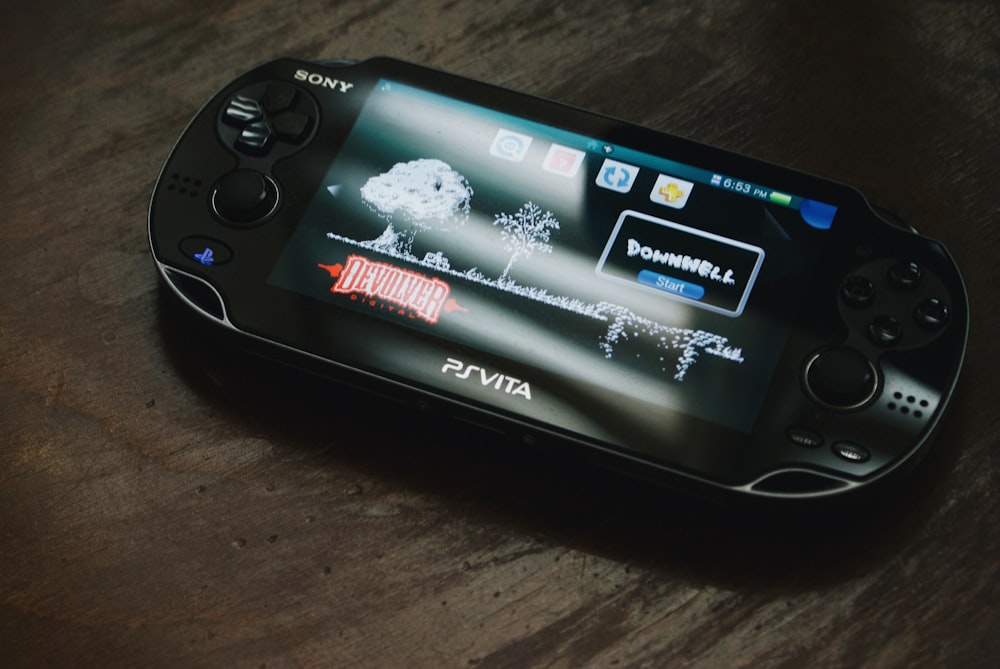 Sony PS Vita negra sobre superficie de madera marrón