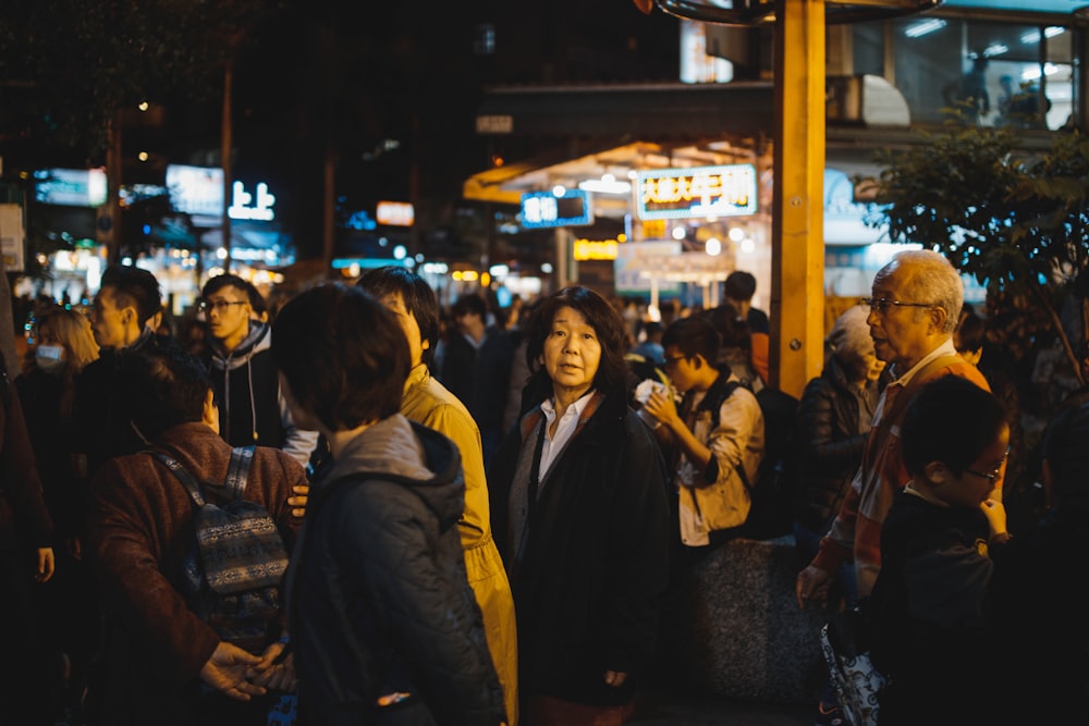 group of people gathering on street during night time
