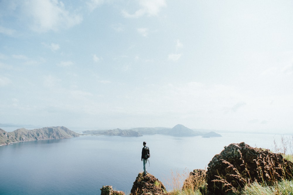 man standing on brown stone during daytime