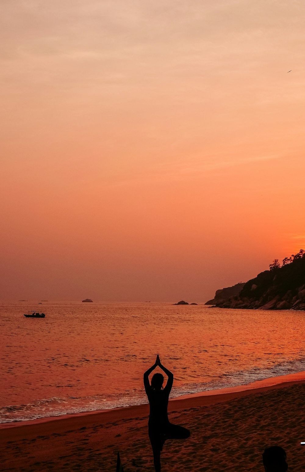 Silhouettenfoto einer Frau, die während des Sonnenuntergangs Yoga macht