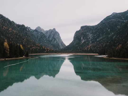 bodies of water near mountains under why sky at daytime in Toblacher See Italy