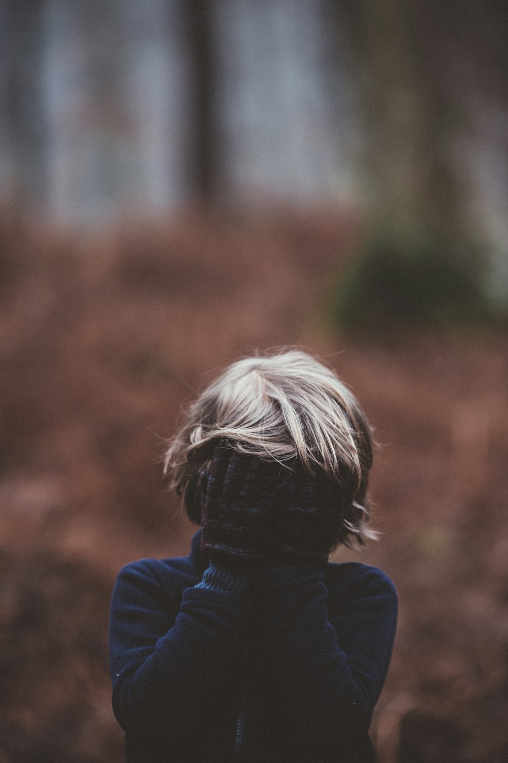 selective photo focus of person covering face