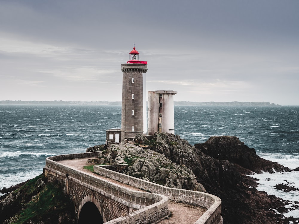 Weißer und roter Leuchtturm in der Nähe eines Gewässers