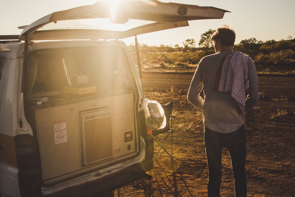 man standing near white van during daytime