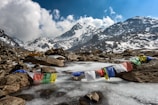 assorted-color of apparel hanged below creek across glacier mountain