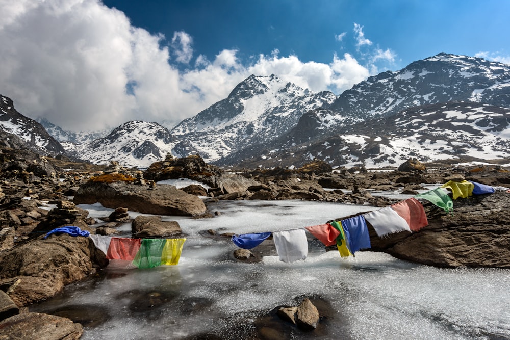 assorted-color of apparel hanged below creek across glacier mountain