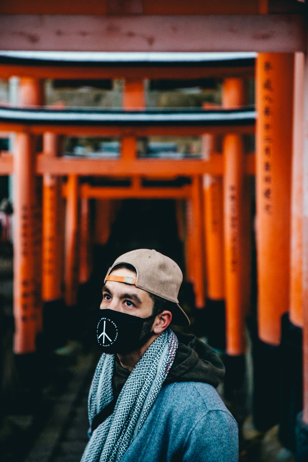 tilt-shift lens photography of of person standing near temple gate during daytime