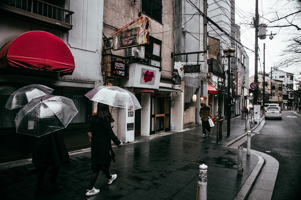 people walking road while raining