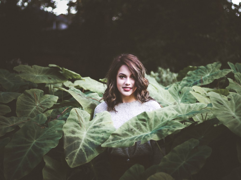 woman standing surrounded by taro leaves