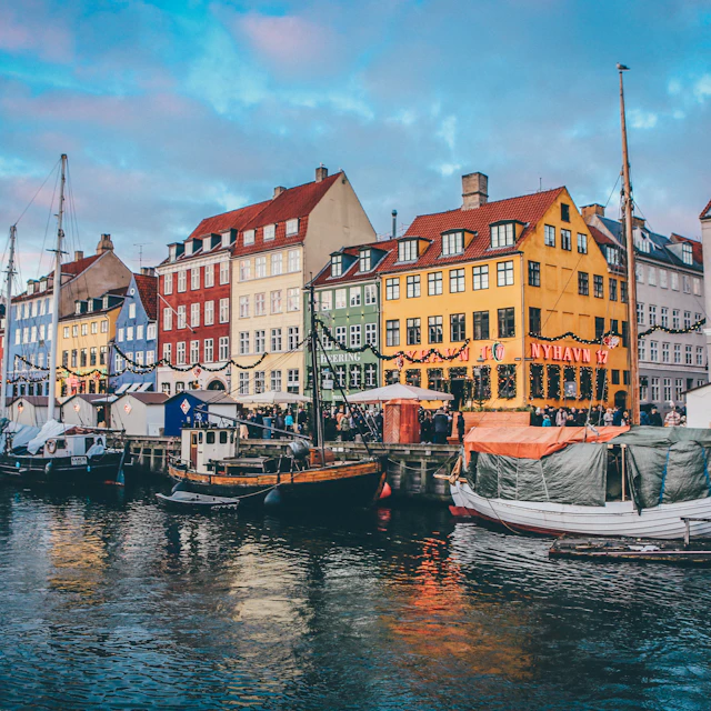 Boats moored along the canal in front of colorful buildings in Nyhavn, Copenhagen