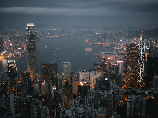 An aerial view of the illuminated skyline and harbor in Hong Kong at night