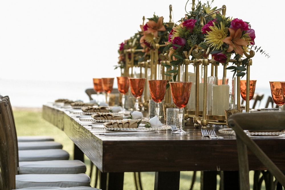 Verres à vin teintés orange sur table à manger rectangulaire en bois brun