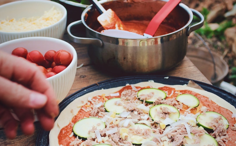 pizza beside sauce and vegetables