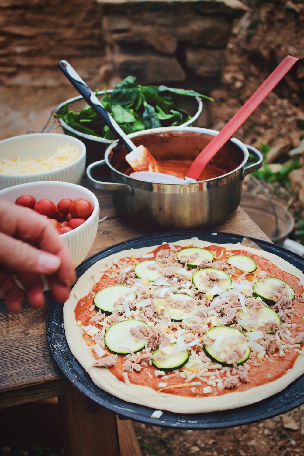 pizza junto a salsa y verduras