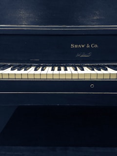 black and white Shaw and Co. upright piano