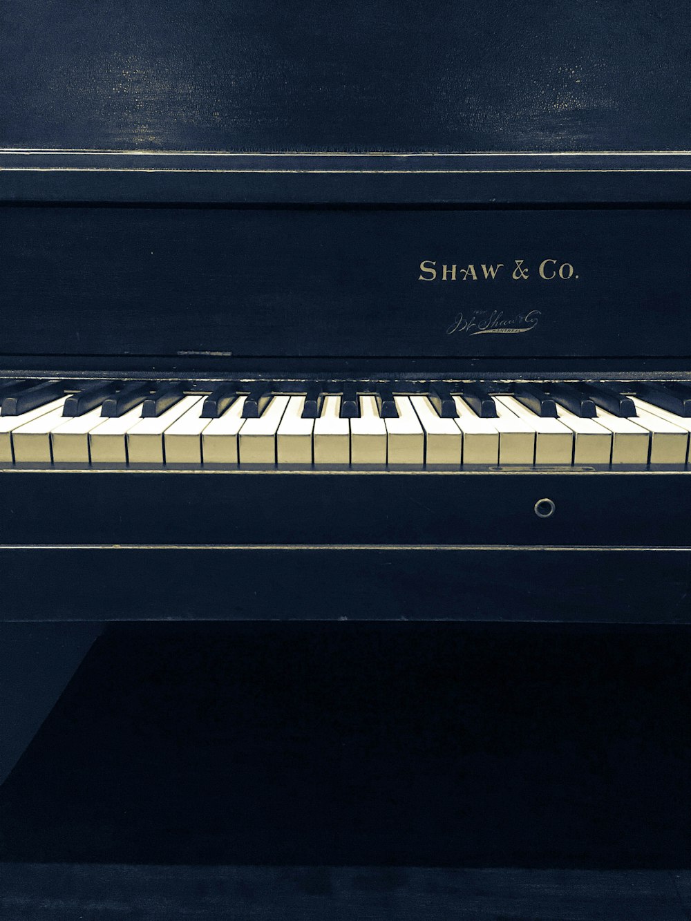 black and white Shaw and Co. upright piano