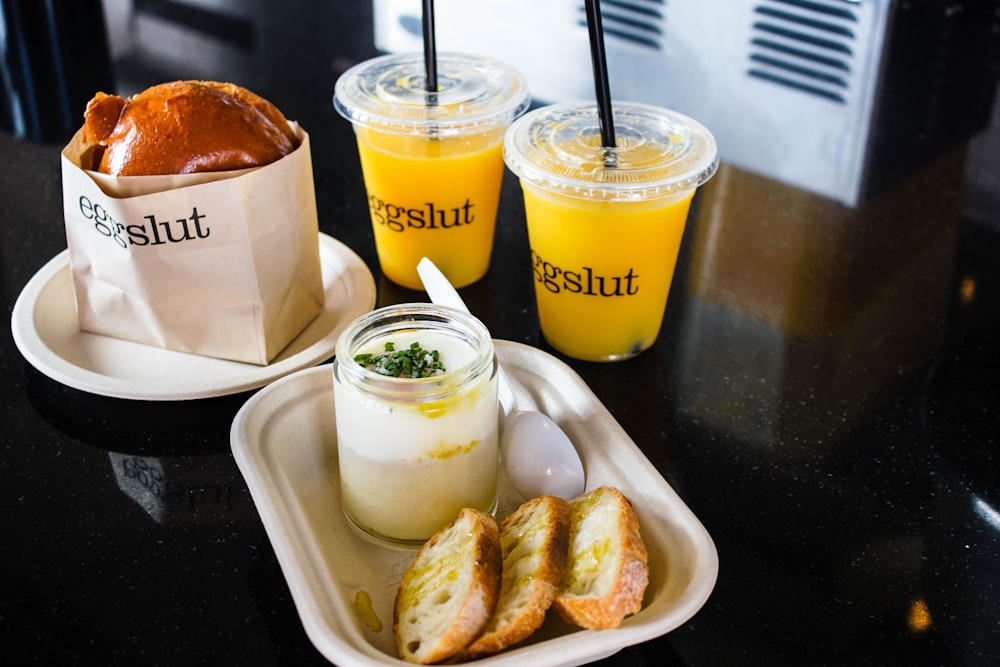 two clear plastic cups filled with yellow liquid