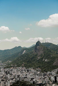 A private tour guide showing a couple the Christ the Redeemer statue with the cityscape in the background.