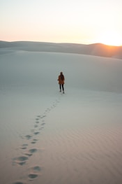 woman walking on dessert during daytime