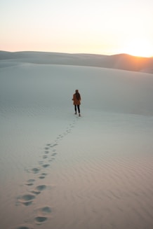 woman walking on dessert during daytime